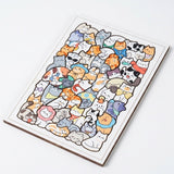 Assembled wooden jigsaw puzzle with colorful cartoon cats and visible brown edges, angled on a white background.