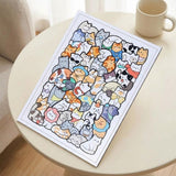 A rectangular cat jigsaw puzzle with colorful illustrations and a white border rests on a round cream table beside a mug.