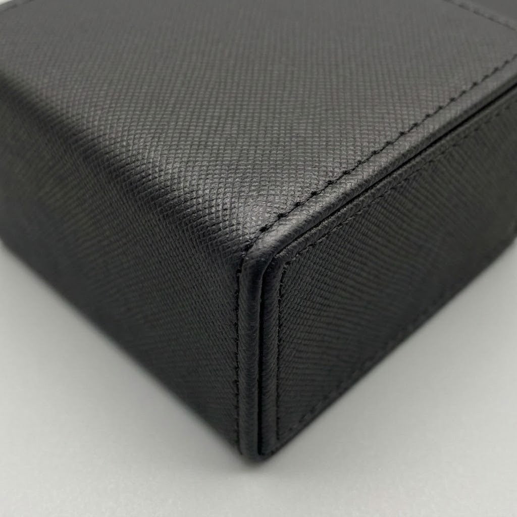 A close-up shows the black deck box’s crosshatched surface, stitched edges, and folded corner against a light gray background.