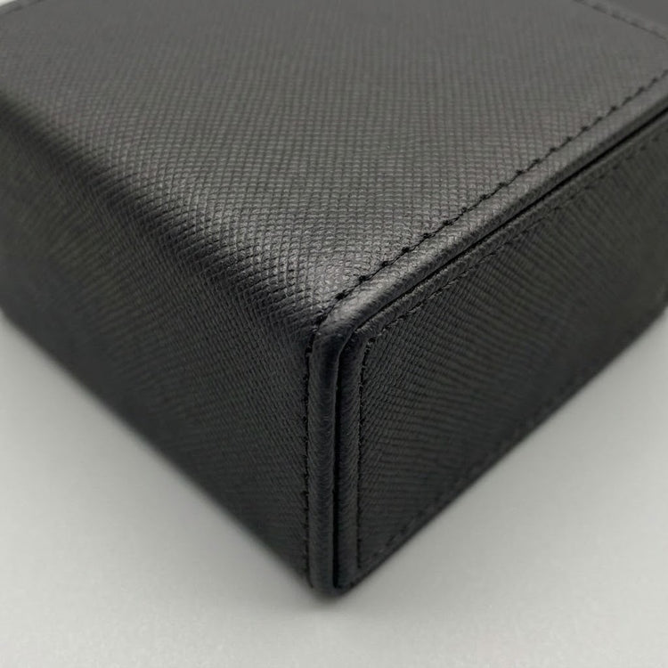 A close-up shows the black deck box’s crosshatched surface, stitched edges, and folded corner against a light gray background.