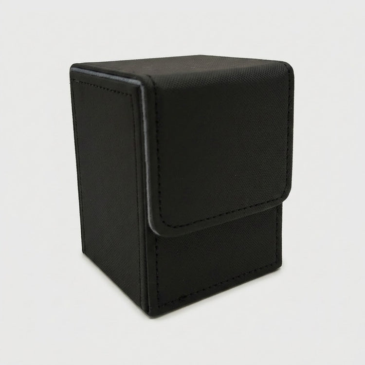 A black textured deck box with gray edging and a closed fold-over flap stands against a light gray background.
