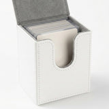An open white deck box holds sleeved cards, showing gray lining, stitched edges, and a curved front opening against a white background.