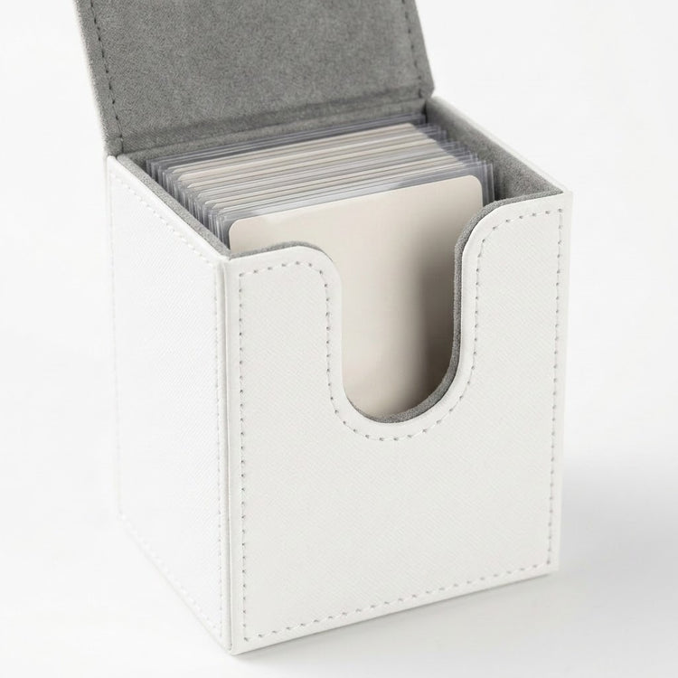 An open white deck box holds sleeved cards, showing gray lining, stitched edges, and a curved front opening against a white background.