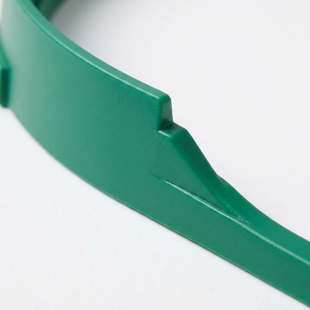 Close-up of the tabletop soccer game's green plastic sidewall, showing its curved edge and molded ridge against a white background.