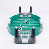 A green and grey tabletop soccer game with white goal nets, dark blue control handles, and two mini footballs on a white background.