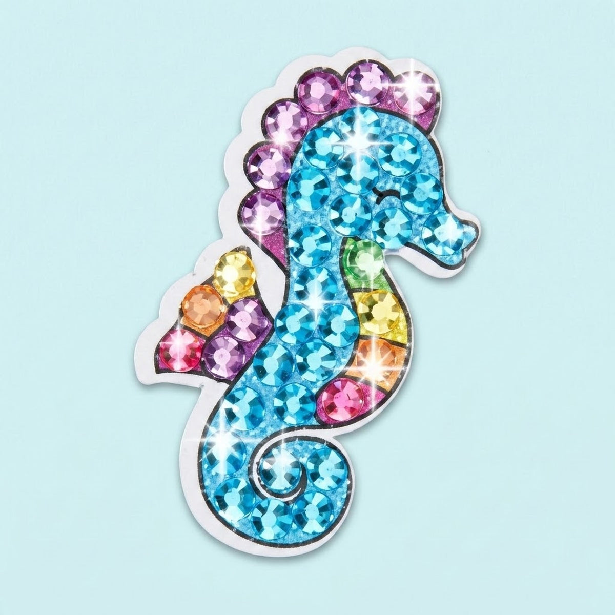 Diamond painting kit seahorse sticker with blue gems, purple edging and multicolored accents against a pale blue background.