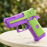 A purple-and-lime-green water gun stands on a pale round tabletop dotted with water droplets against blurred garden greenery.