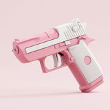 Pink and white water gun with a textured white grip and white trigger points left against a pale pink background.