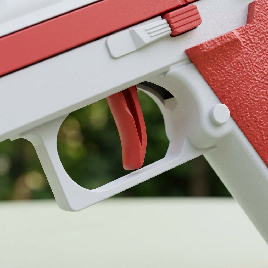 Close-up of a water gun showing its red trigger, white trigger guard, and textured red grip against blurred greenery.