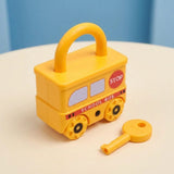 A yellow school bus lock puzzle with a closed shackle and separate yellow key rests on a cream tabletop against a blue background.