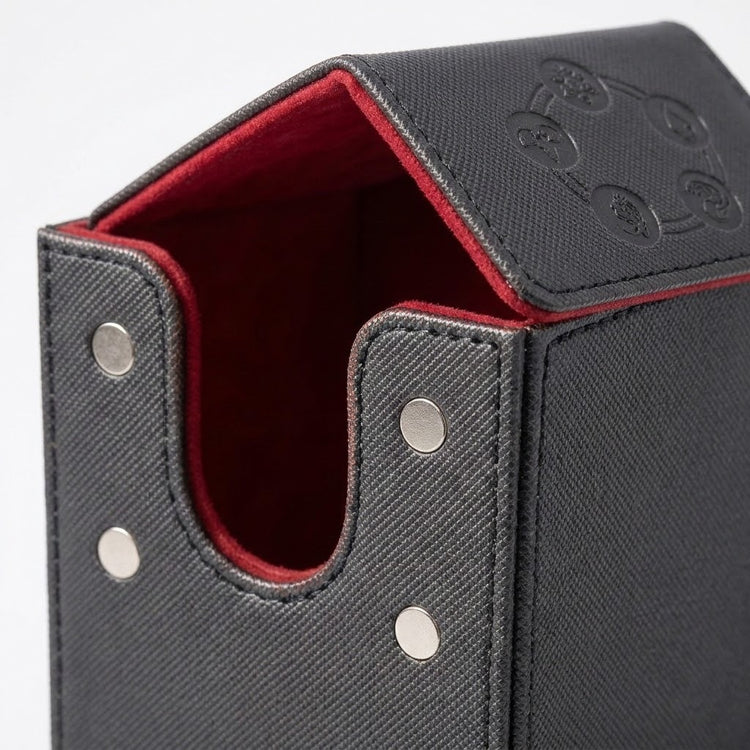 Close-up of a partially open black deck box shows four silver magnetic contacts, red velvet lining, and an embossed lid.