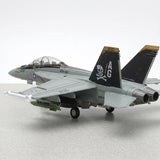 Assembled gray plastic aircraft model kit viewed from behind, with black pirate tail fins and extended landing gear on a gray surface.