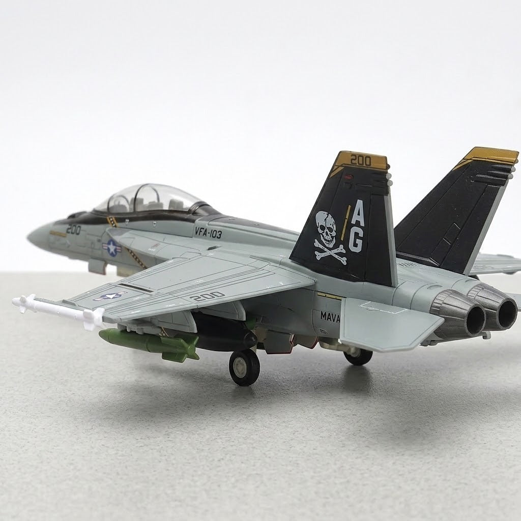 Assembled gray plastic aircraft model kit viewed from behind, with black pirate tail fins and extended landing gear on a gray surface.
