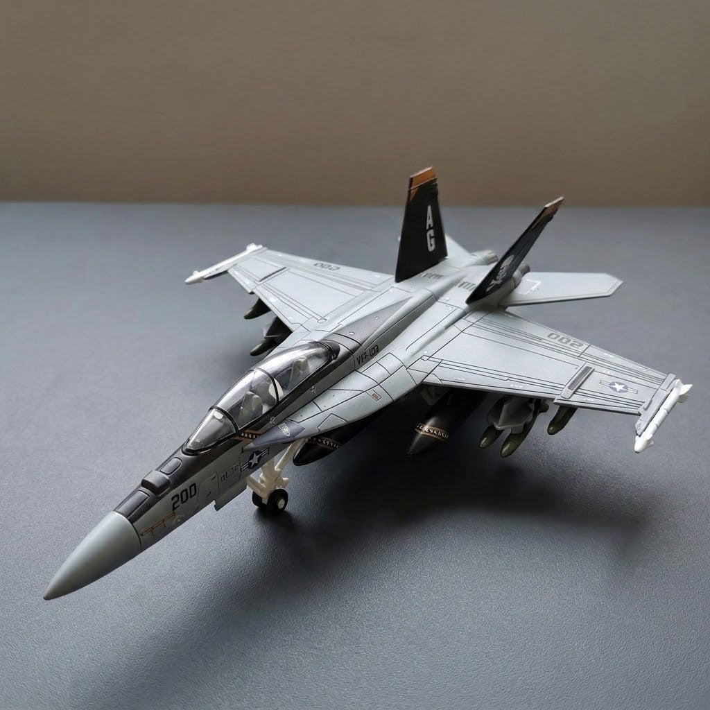 Assembled gray plastic aircraft model kit sits diagonally on a gray surface with a clear canopy, extended landing gear, and black tail fins.