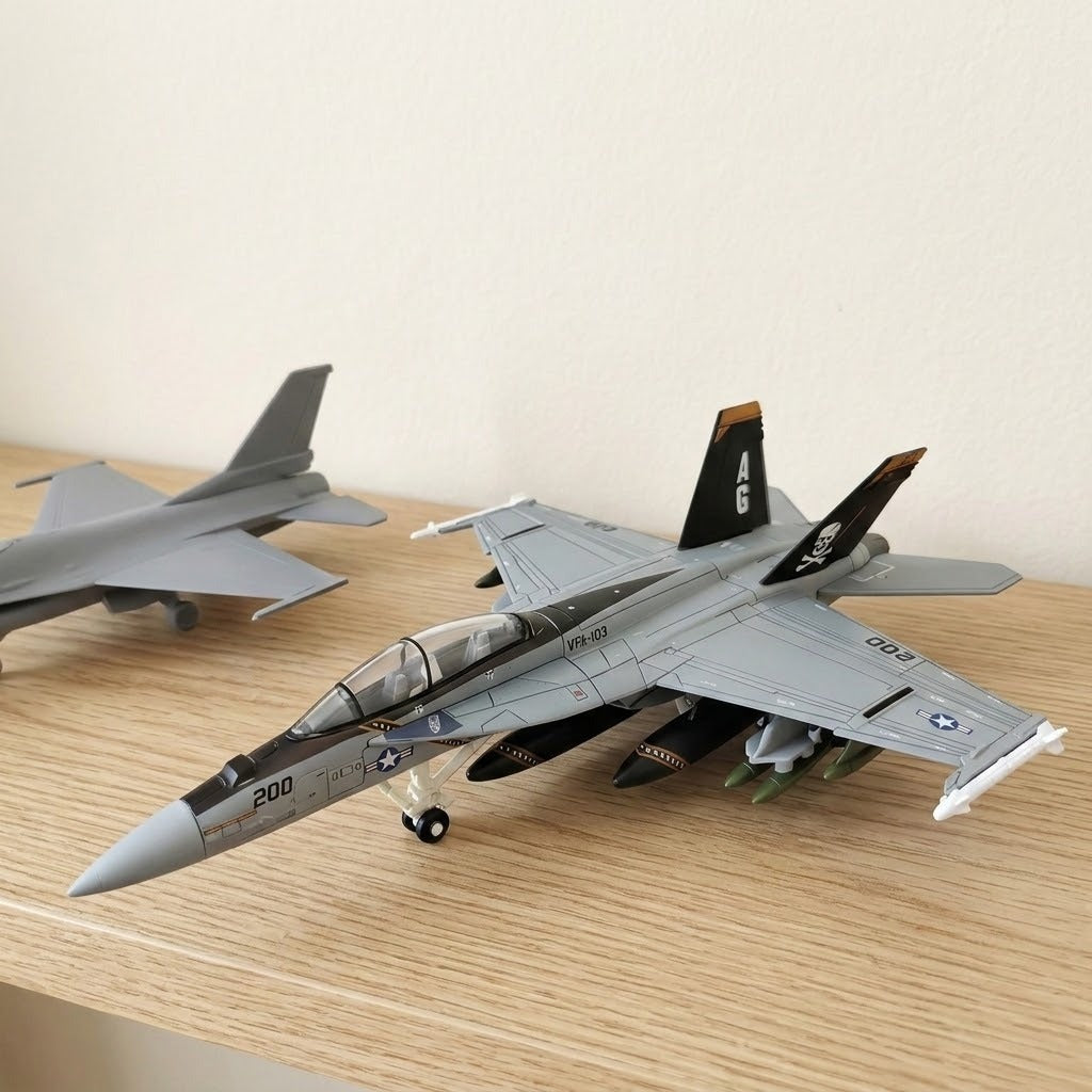 Assembled gray plastic aircraft model kit with pirate-marked tail fins rests on a wooden shelf beside another partially visible gray aircraft.