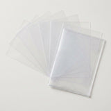 Empty clear card sleeves fan out behind an overlapping stack on a light neutral background.