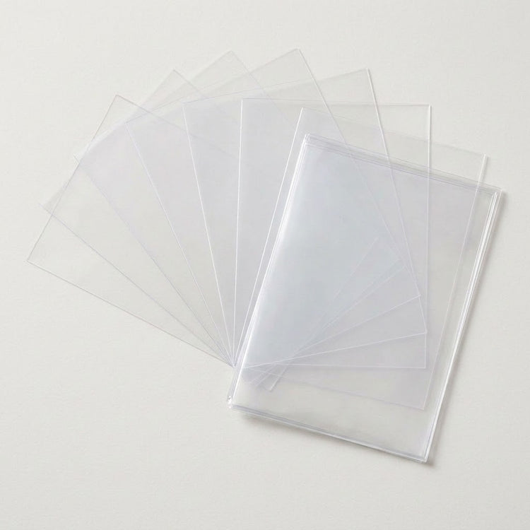 Empty clear card sleeves fan out behind an overlapping stack on a light neutral background.