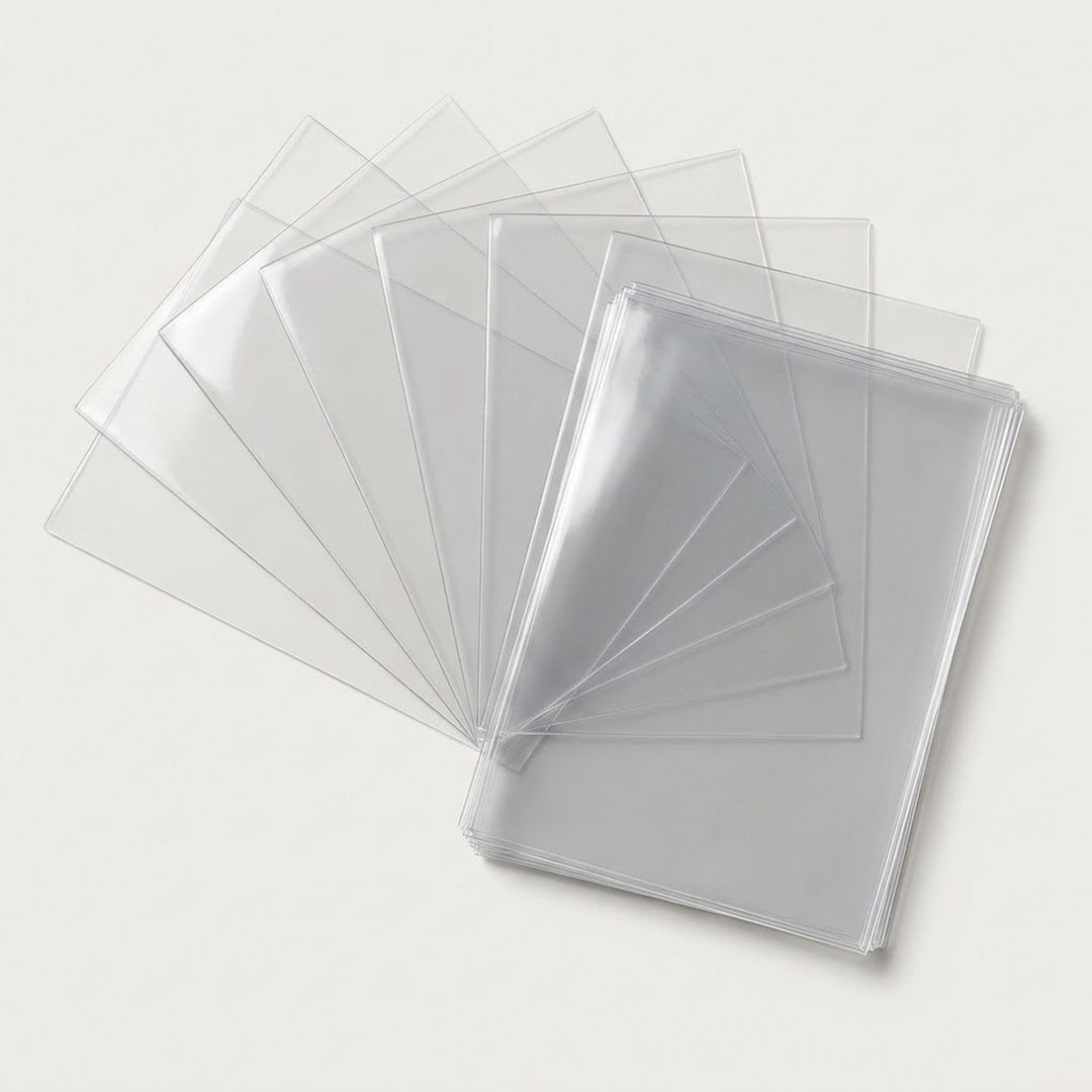 Clear PVC card sleeves fan out beside a neat stack on a light warm gray background.
