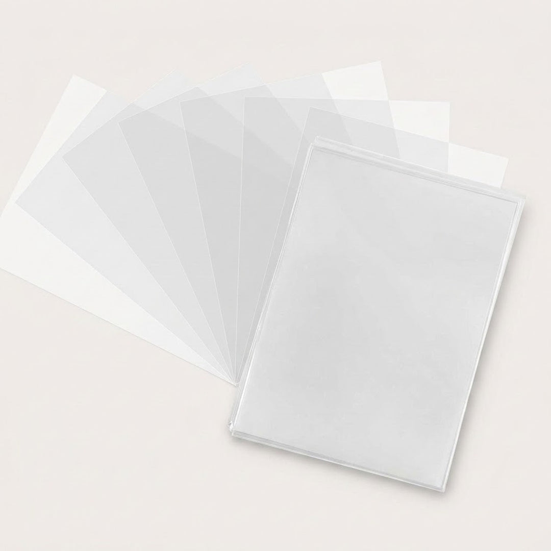 Clear rectangular card sleeves spread in a broad fan behind an overlapping front stack on an off-white surface.