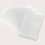 Clear rectangular card sleeves spread in a broad fan behind an overlapping front stack on an off-white surface.