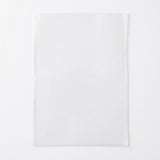 A single empty clear rectangular card sleeve lies flat on a white background with faint shadows around its edges.