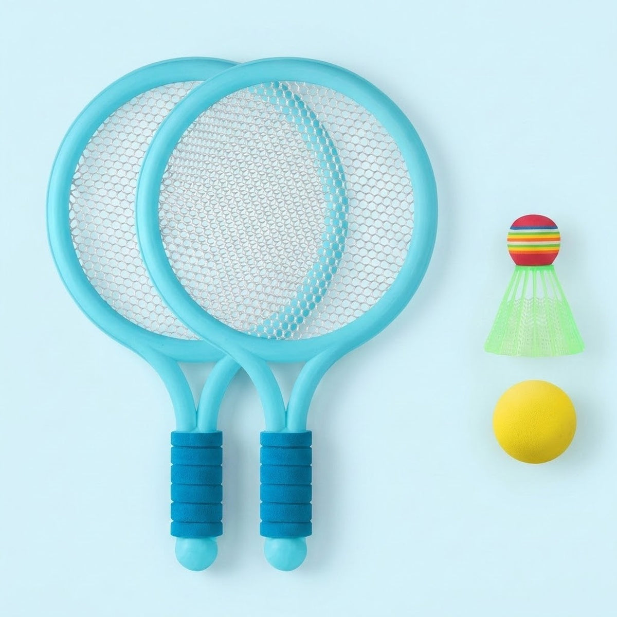 The toy racket set shows two overlapping light blue rackets with dark blue grips, a green shuttlecock, and yellow ball against pale blue.