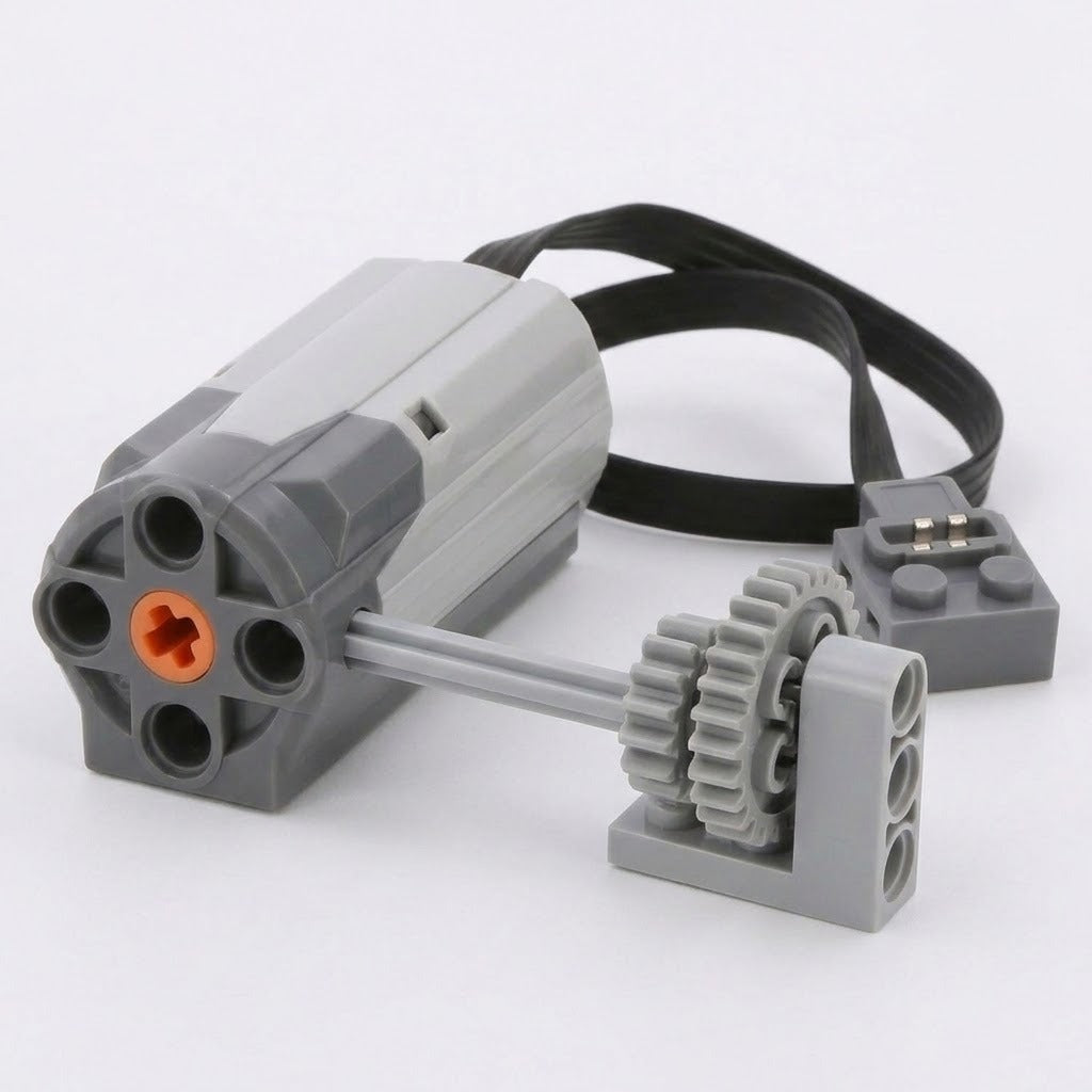 Gray building block accessory motor with an orange axle opening, black cable, and two interlocking gray gears rests on a white background.