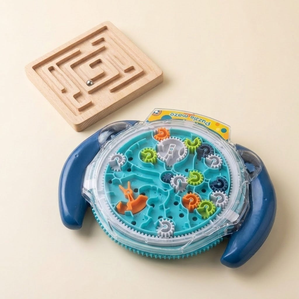 A children's toy puzzle set on a warm beige background, featuring a round blue and clear plastic gear game with colorful gears, a wooden maze board, and a small metal ball.