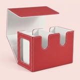 Red textured deck box with white lining stands open on a pale pink background, showing two compartments and a side display window.