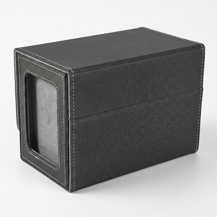 A closed black deck box shows its wraparound cover, white stitching, and gray-backed side display window against a light background.