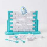A turquoise and white balance game has gaps between blocks, a tilted blue penguin, and loose blocks and tools against a white background.