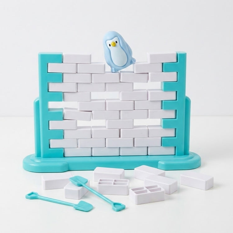 A turquoise and white balance game has gaps between blocks, a tilted blue penguin, and loose blocks and tools against a white background.