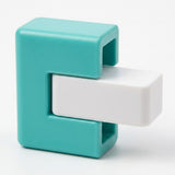 A close-up of the balance game shows a white plastic block fitted into a turquoise frame against a white background.
