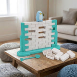 A turquoise and white balance game with missing blocks and a blue penguin sits on a wooden living room table beside loose pieces.