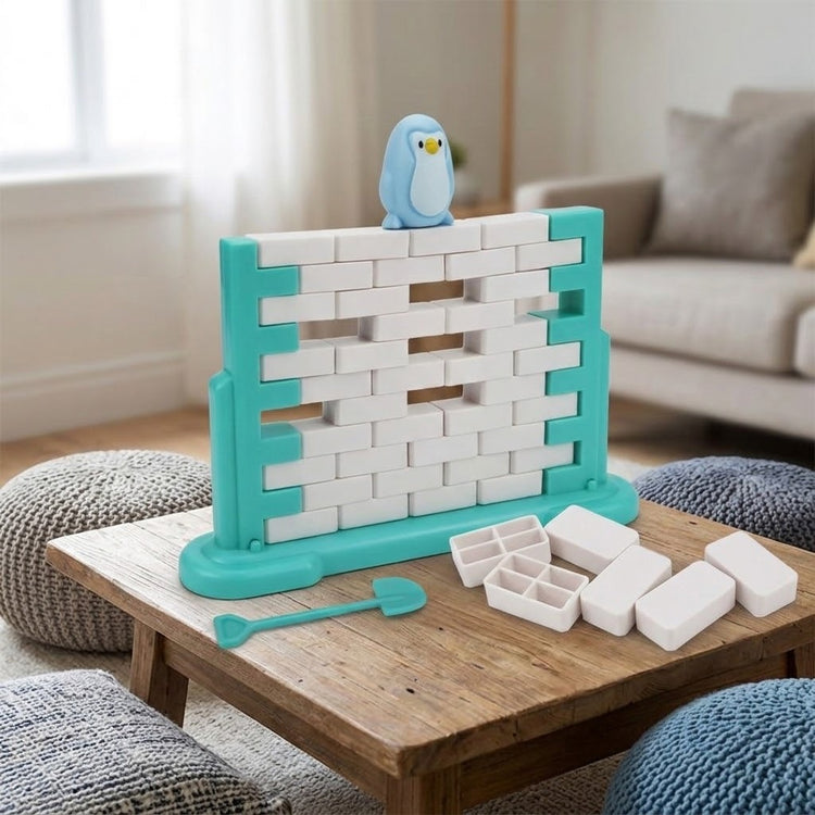 A turquoise and white balance game with missing blocks and a blue penguin sits on a wooden living room table beside loose pieces.