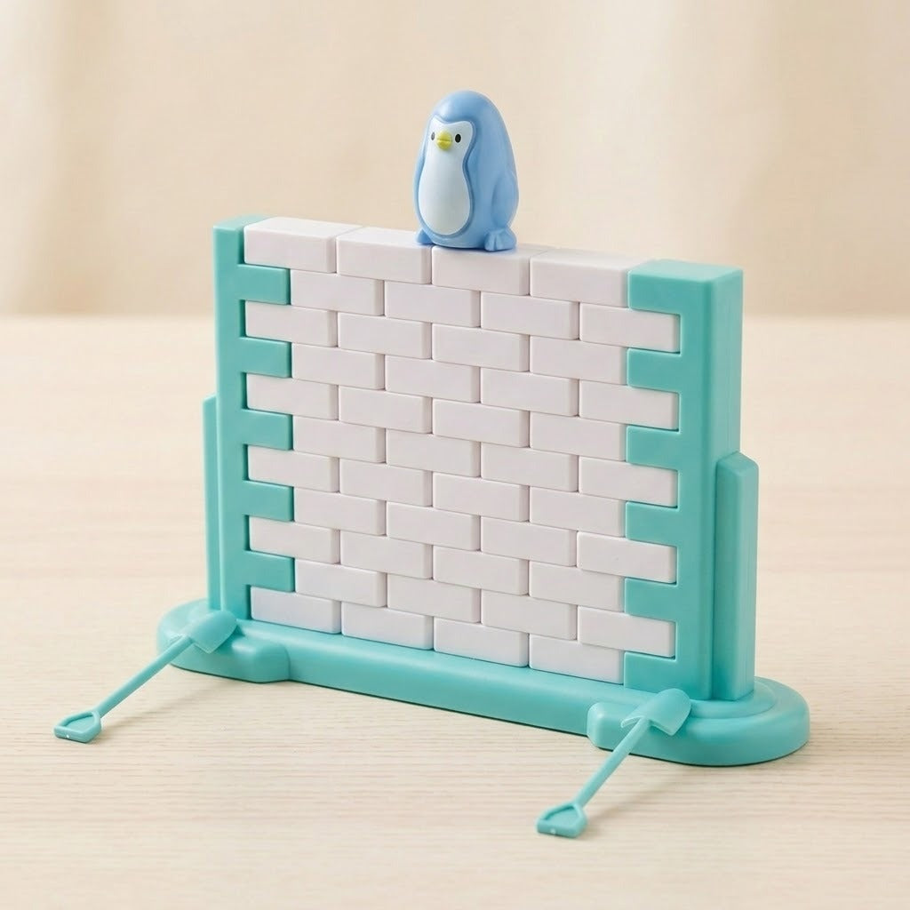 Assembled penguin balance game showing a blue penguin figure on a white block wall with turquoise frame on a wooden surface.