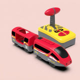 A children's toy set featuring a red and gray toy train with open side windows, a yellow and gray remote control with a red knob, and small printed graphics including 'CITY trains'. The products are arranged on a solid pale pink background.
