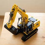 A yellow and black building block excavator toy constructed from LEGO-style bricks, photographed on a light wood tabletop against a soft beige background.