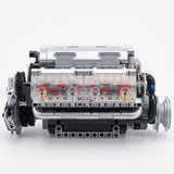 Silver plastic V8 engine model kit shown assembled from the side, with transparent panels revealing red components against a white background.
