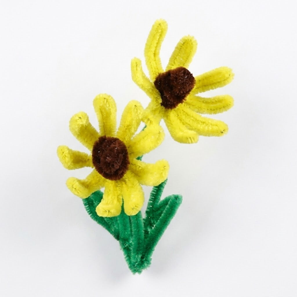 Craft kit project example featuring two yellow pipe cleaner flowers with brown centers and green stems against a white background.