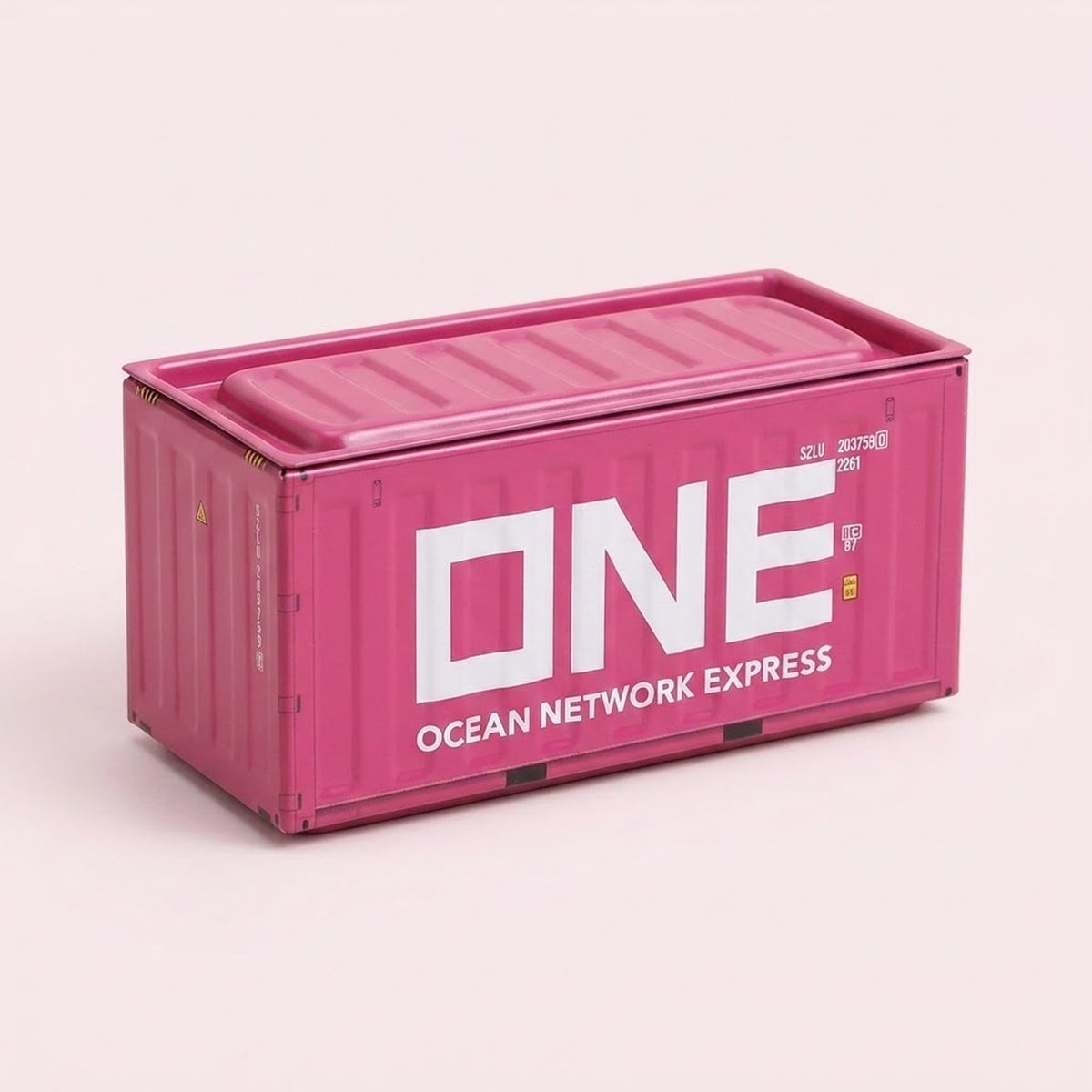 A pink metal storage box with large white lettering, ribbed sides, and a closed lid sits against a pale pink background.
