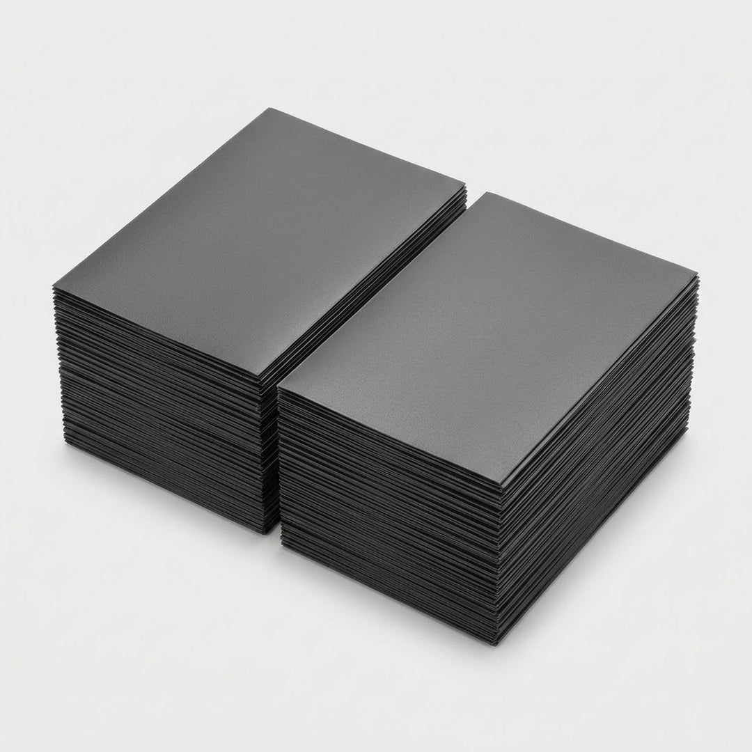 Two stacks of dark gray matte polypropylene card sleeves sit side by side on a light gray background.