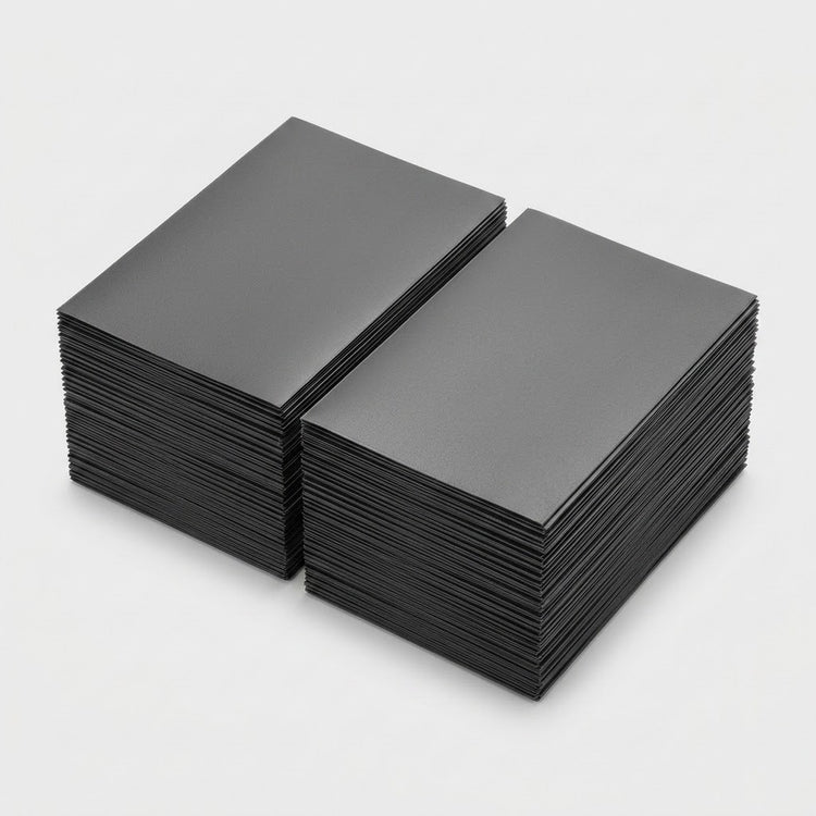 Two stacks of dark gray matte polypropylene card sleeves sit side by side on a light gray background.