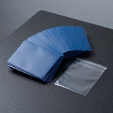 Blue matte polypropylene card sleeves fanned beside a single empty clear packaging bag on a dark gray playmat.