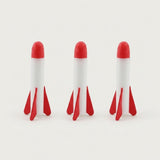 Three foam rockets for the rocket launcher stand in a row, with white bodies, red tips and fins against a light background.