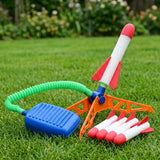 A rocket launcher on a lawn holds one red-and-white rocket, with four spare rockets beside its orange base and blue pedal.