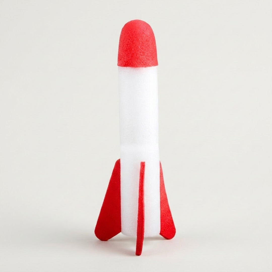 A single red-and-white foam rocket for the rocket launcher stands upright on its red fins against a light gray background.