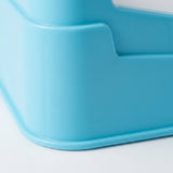 Close-up of the blue tabletop soccer game's rounded plastic corner and raised base edge against a white background.