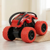 Red toy car with black protective bars and oversized treaded wheels sits partly on a wooden ramp against a cream background.