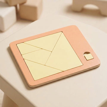 A wooden geometric puzzle with pale yellow pieces fills a peach tray on a cream table, with blurred wooden blocks behind.
